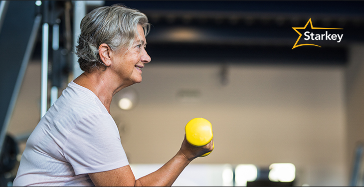 Image of a senior woman preparing to throw a ball at the gym